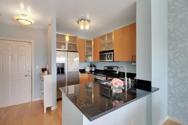 a kitchen with stainless steel appliances granite countertop a sink a stove and a refrigerator