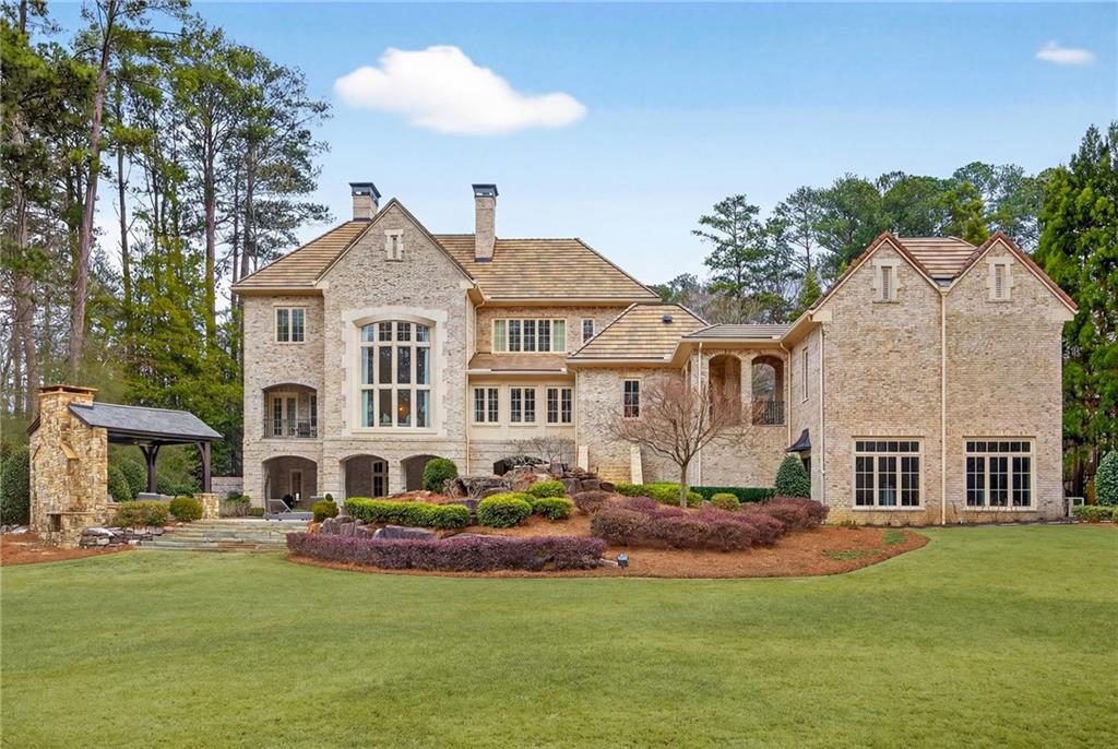 5148 Powers Ferry Road Northwest Sandy Springs, GA 30327 - Photo 58 of 63 a front view of a house with a garden and plants