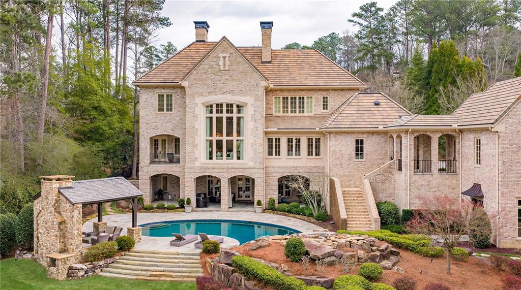 5148 Powers Ferry Road Northwest Sandy Springs, GA 30327 - Photo 59 of 63 a front view of house with yard outdoor seating and trees in the background