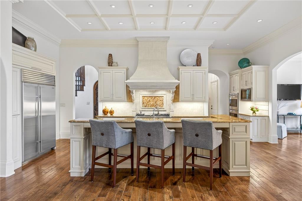 5148 Powers Ferry Road Northwest Sandy Springs, GA 30327 - Photo 9 of 63 a kitchen with stainless steel appliances a table chairs refrigerator and cabinets