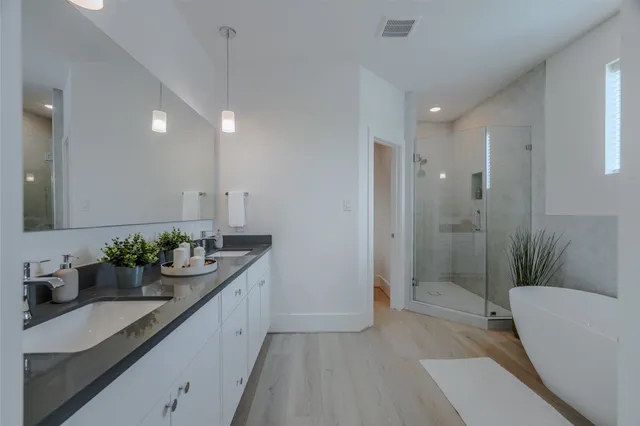 a bathroom with a double vanity sink mirror and shower