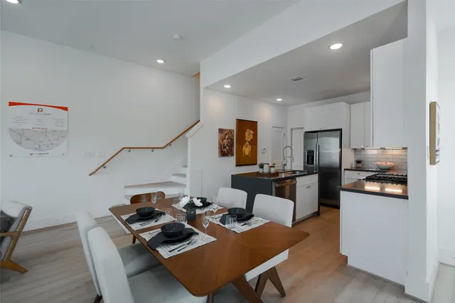 a living room with furniture kitchen view and a wooden floor