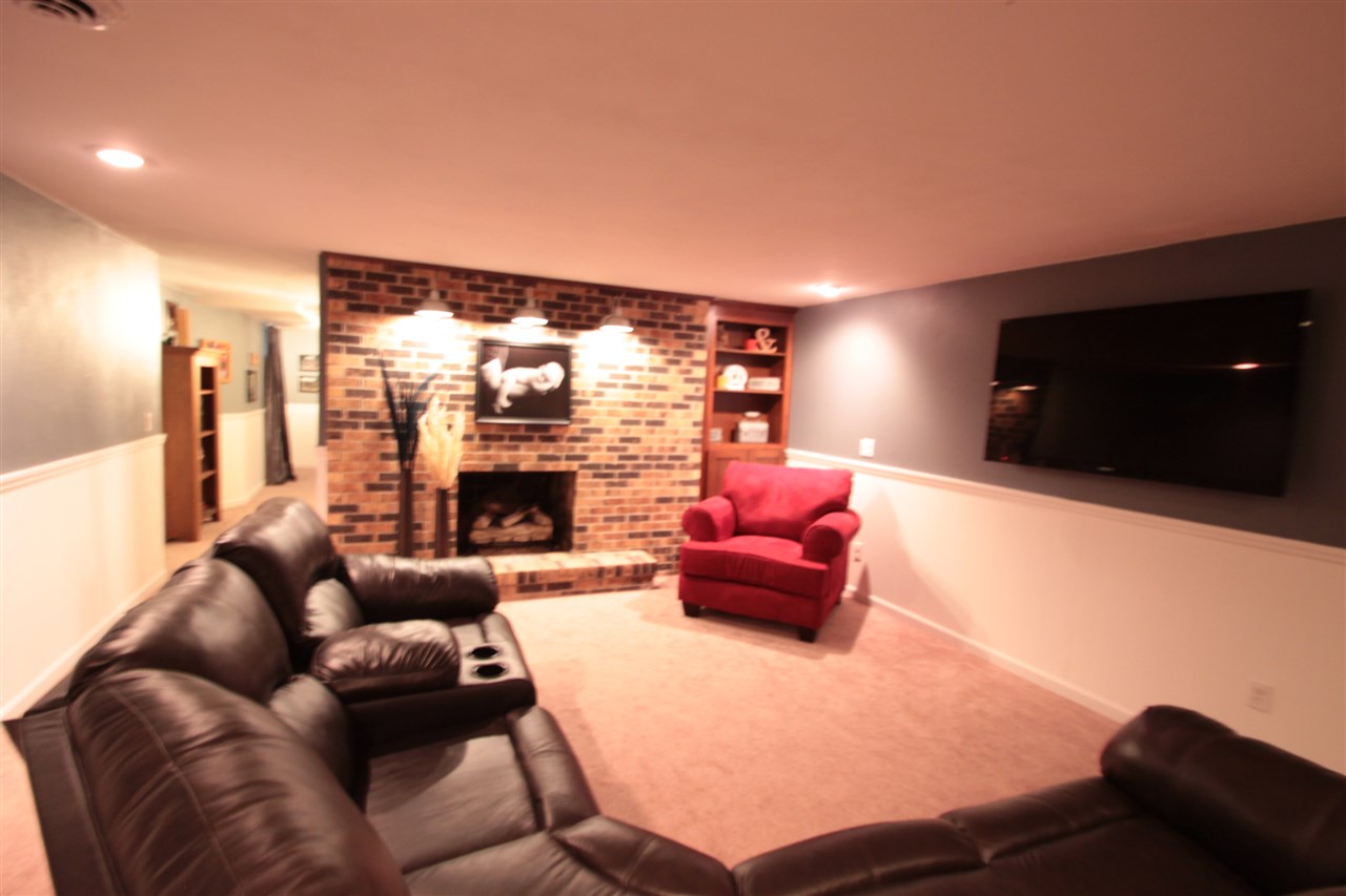 1138 Roxbury Road Rockford, IL 61107 - Photo 19 of 25 a living room with furniture a fireplace and a flat screen tv