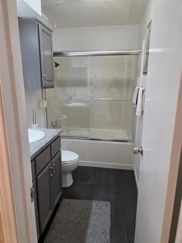 a bathroom with a granite countertop shower toilet and sink
