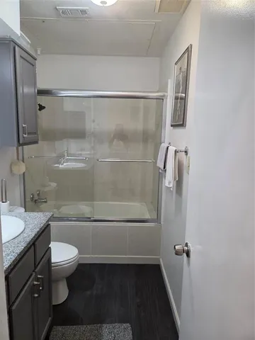 a bathroom with a granite countertop sink toilet and shower