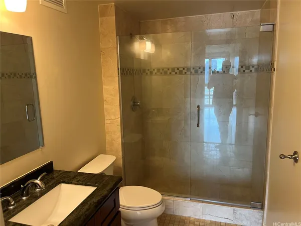 a bathroom with a granite countertop sink toilet and shower