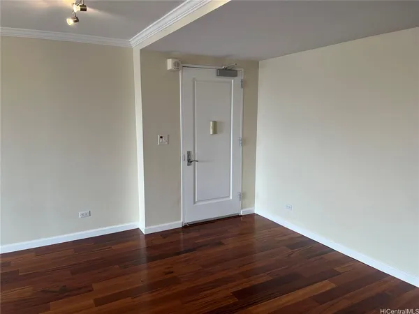 a view of an empty room with wooden floor