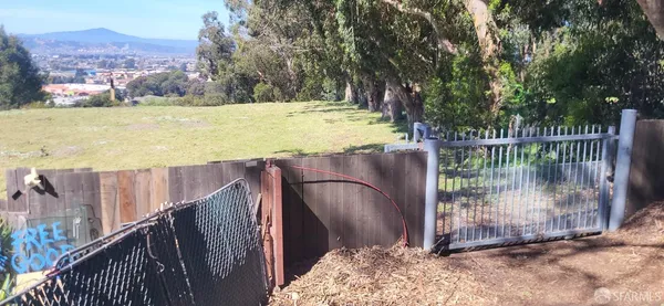 a view of a backyard with a garden and wooden fence