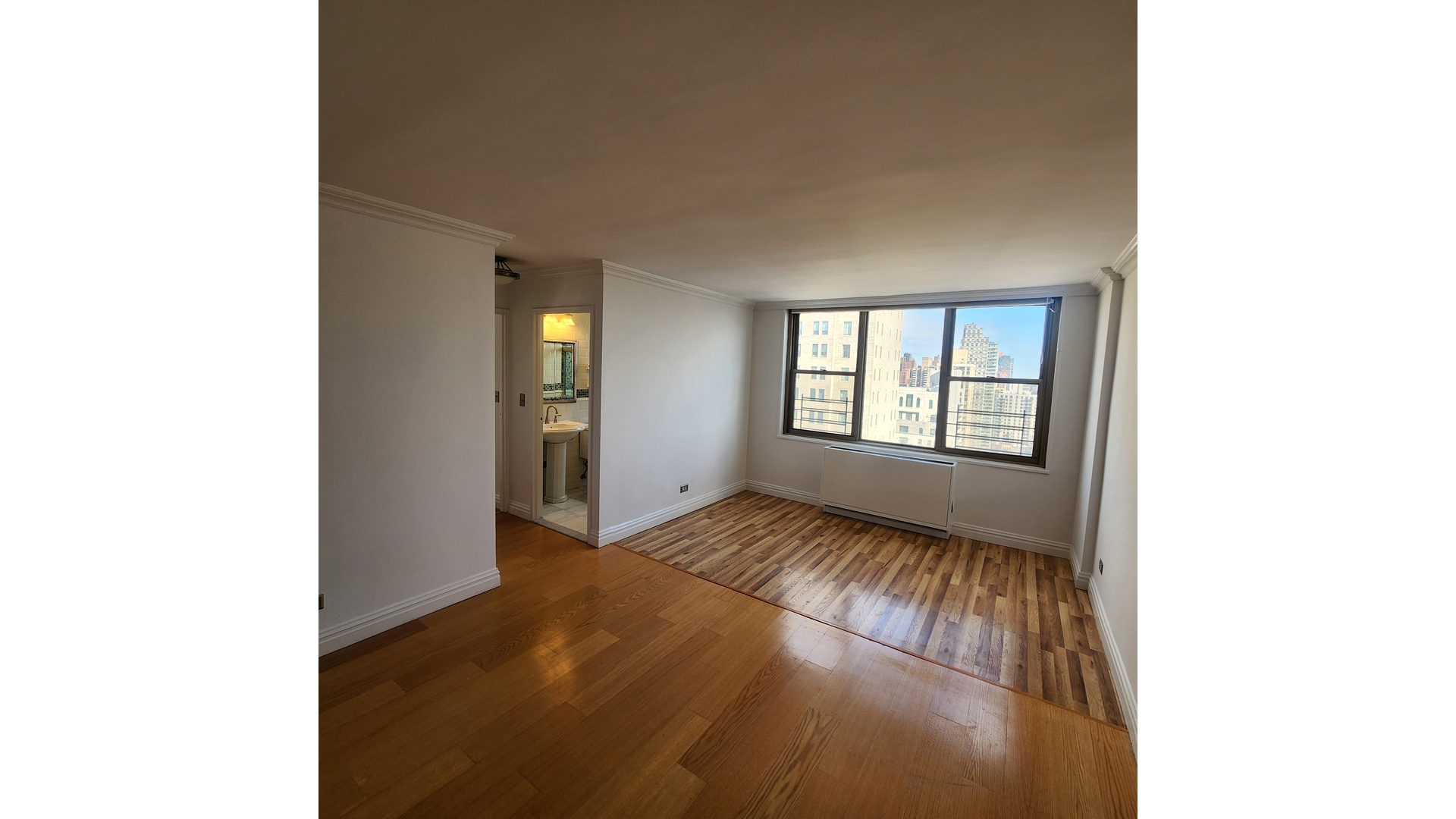 301 East 79th Street, Unit 32F Manhattan, NY 10075 - Photo 4 of 21 a view of an empty room with chandelier and a window
