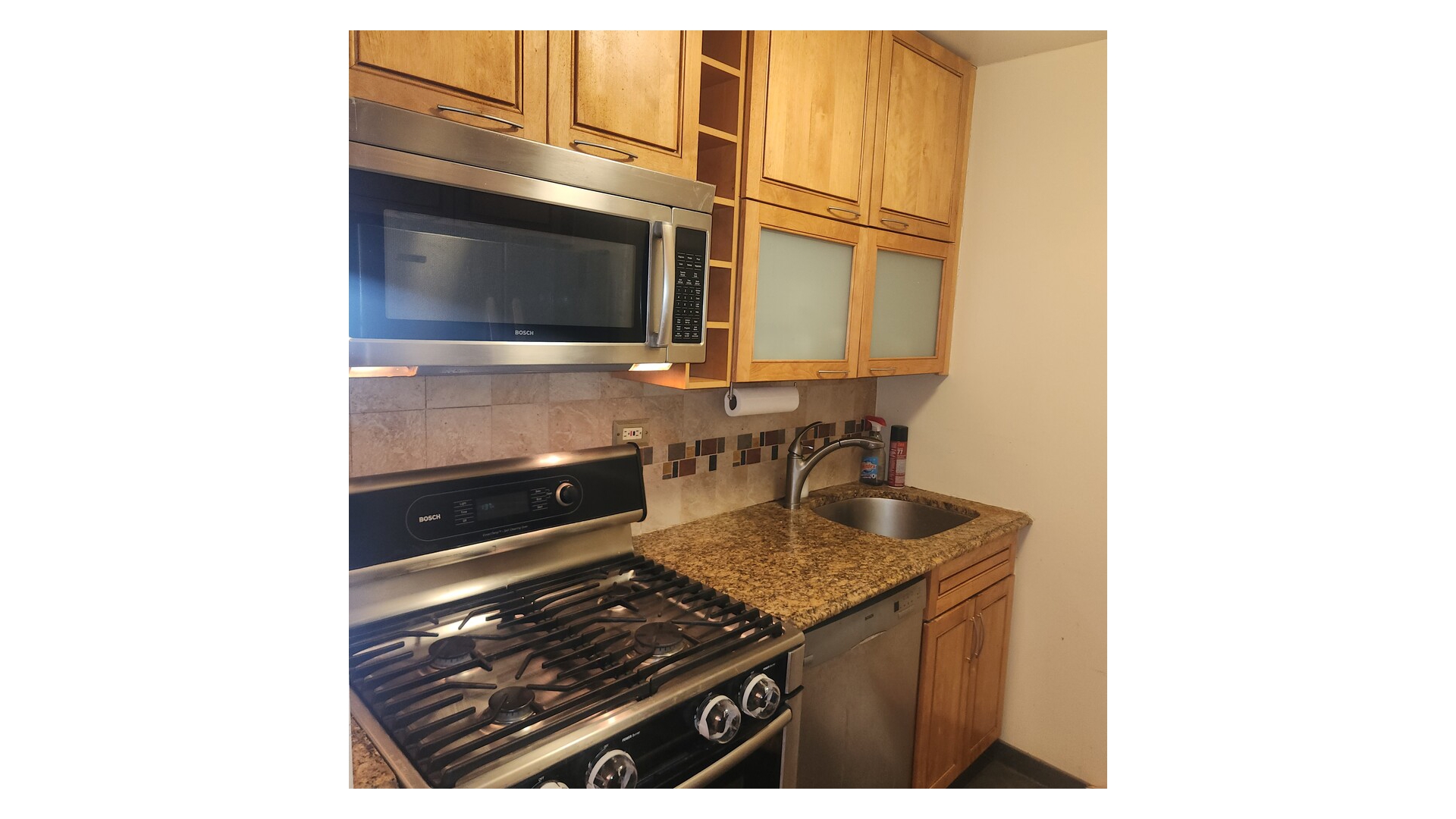 301 East 79th Street, Unit 32F Manhattan, NY 10075 - Photo 6 of 21 a kitchen with a stove and a microwave
