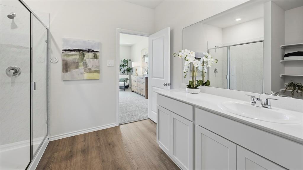 1957 Freeman Street Tyler, TX 75704 - Photo 18 of 25 Spacious bathroom featuring a white vanity with an integrated sink, a large wall-mounted mirror, and a glass-enclosed shower