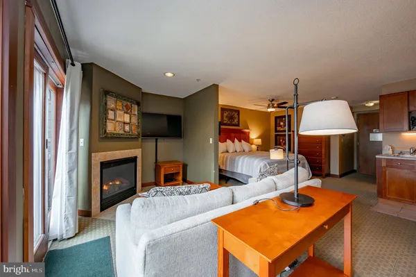 a living room with furniture a flat screen tv and a fireplace