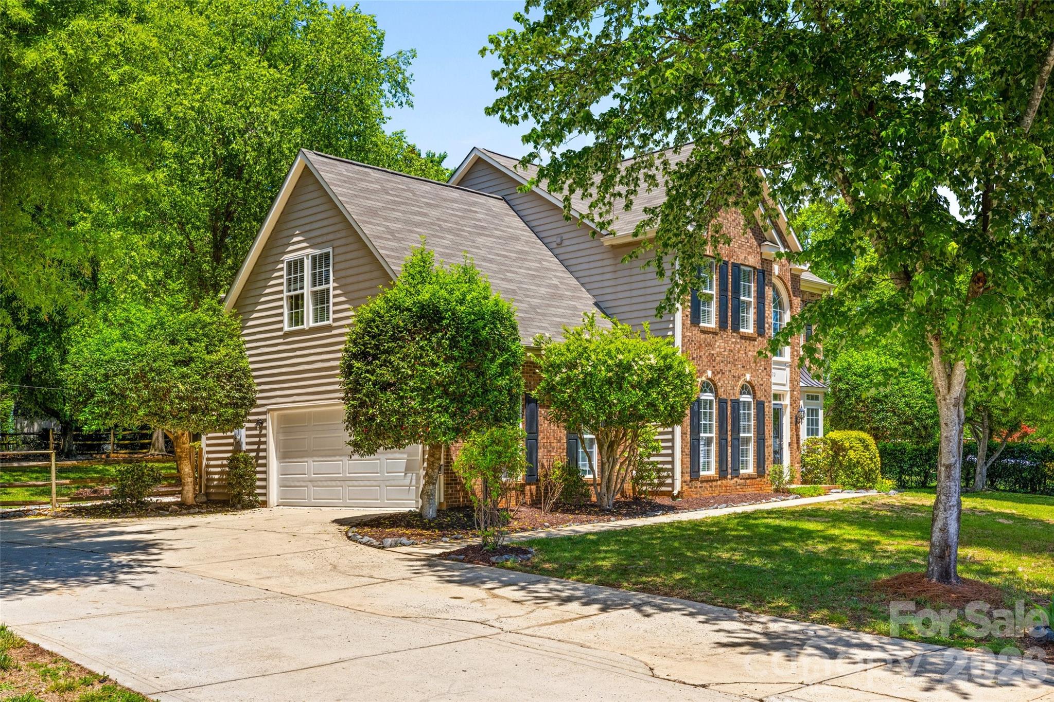 620 East Cheval Drive Fort Mill, SC 29708 - Photo 2 of 48 a view of a brick house with a yard plants and large tree