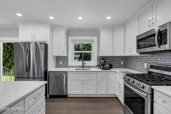a kitchen with stainless steel appliances a stove sink and microwave