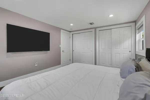 a bedroom with a bed tv and a window