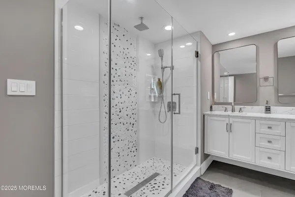 a bathroom with a shower sink and mirror