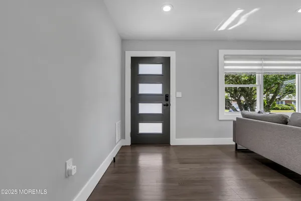 an empty room with large window and wooden floor