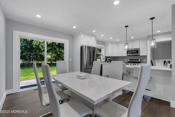a kitchen with a table chairs refrigerator and microwave