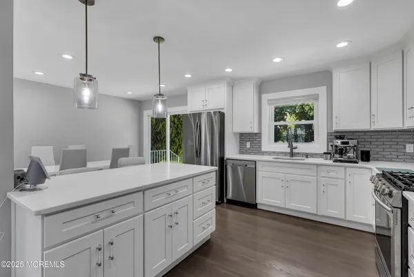 a kitchen with white cabinets and sink