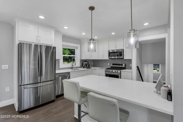 a kitchen with a refrigerator a stove a sink and a microwave