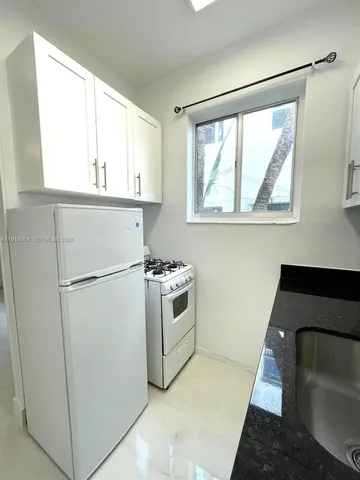 a kitchen with a refrigerator and window