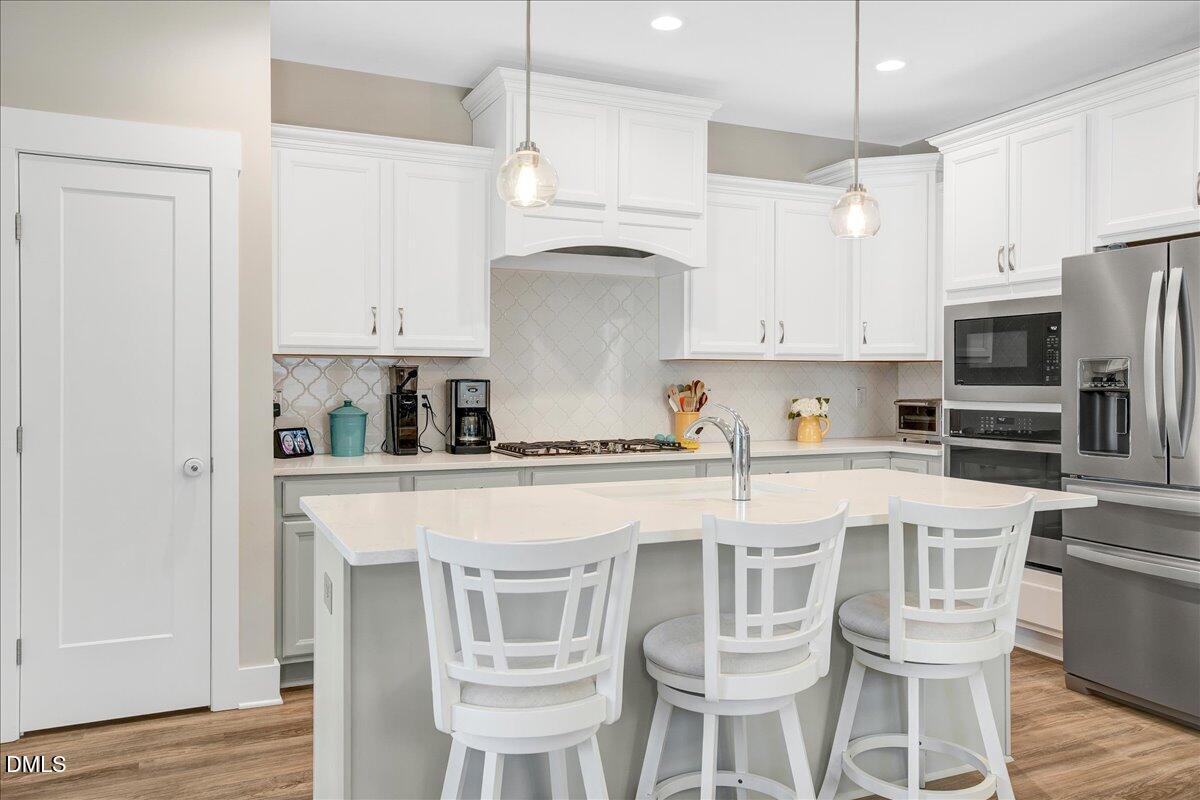 1105 Logperch Way Wendell, NC 27591 - Photo 5 of 29 a kitchen with stainless steel appliances granite countertop a white table and chairs