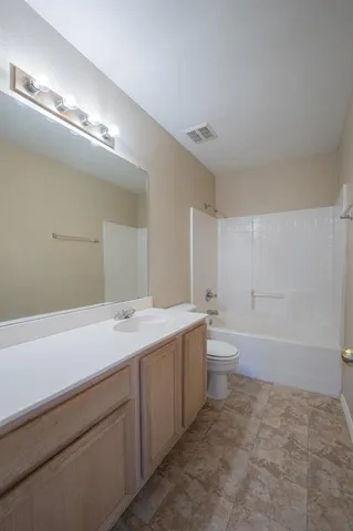 a bathroom with a granite countertop sink a toilet and bathtub