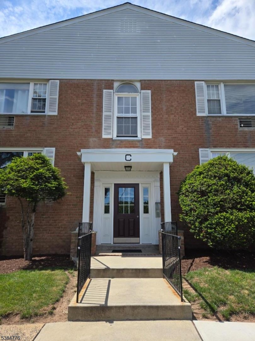 565 Grove Street, Unit C15 Clifton, NJ 07013 - Photo 2 of 11 a front view of a house with a garden
