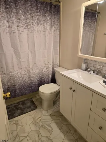 a bathroom with a toilet a sink and shower