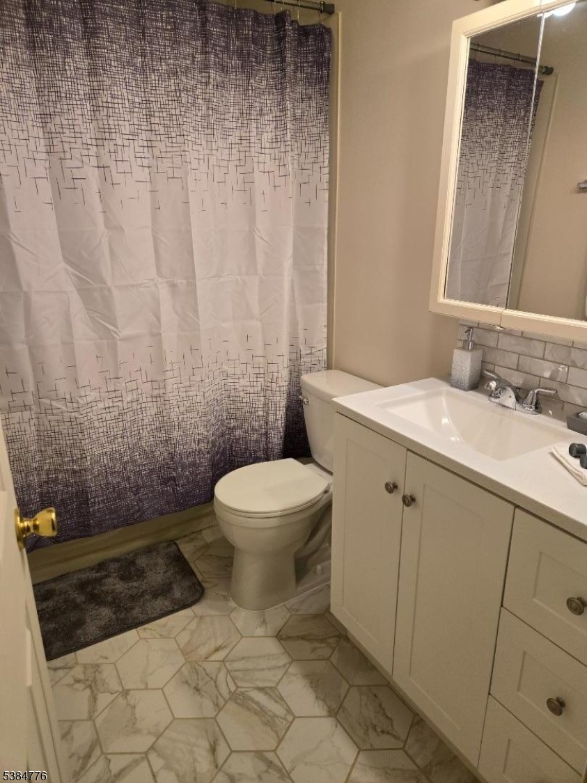 565 Grove Street, Unit C15 Clifton, NJ 07013 - Photo 9 of 11 a bathroom with a toilet a sink and shower