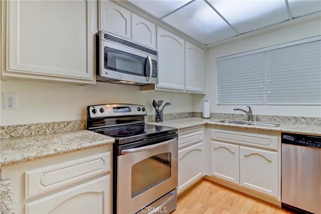 a kitchen with stainless steel appliances granite countertop a sink a stove and microwave