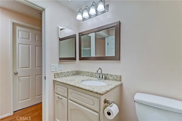 a bathroom with a granite countertop toilet sink and mirror