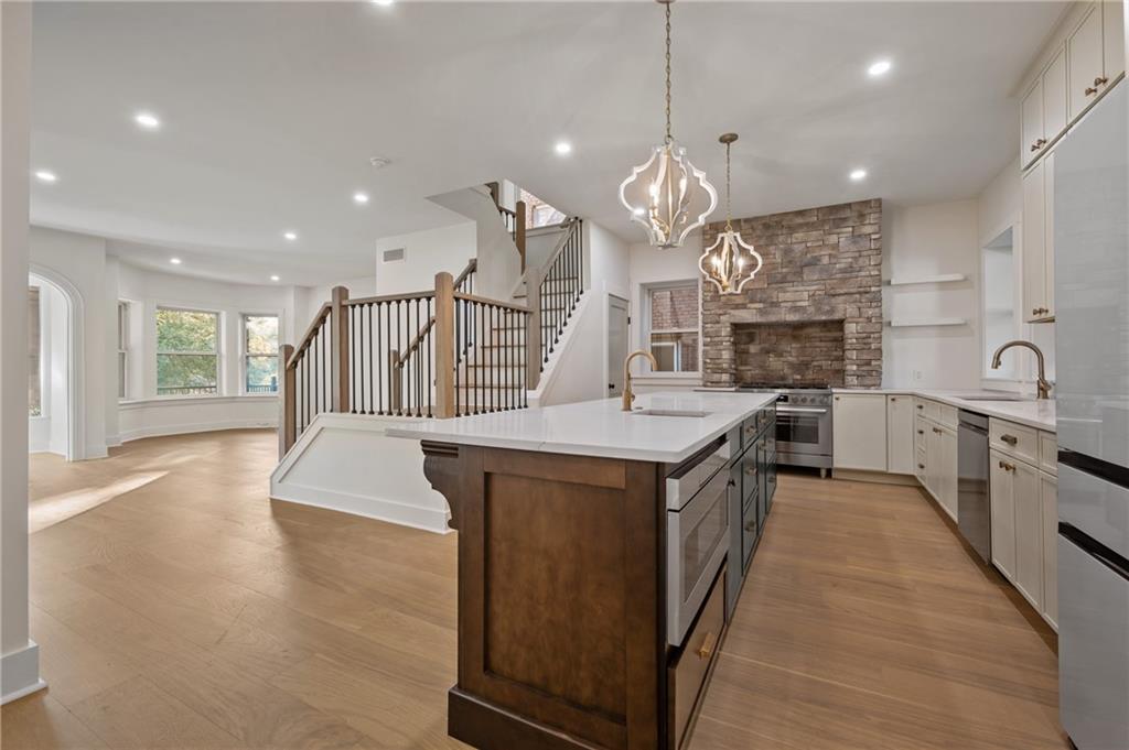 5563 Hampton Street Pittsburgh, PA 15206 - Photo 11 of 29 a kitchen with granite countertop a sink a counter top space stainless steel appliances and a chandelier