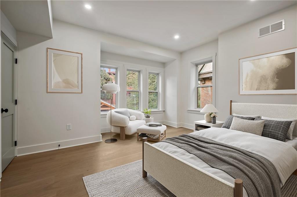 5563 Hampton Street Pittsburgh, PA 15206 - Photo 19 of 29 a bedroom with a bed and wooden floor