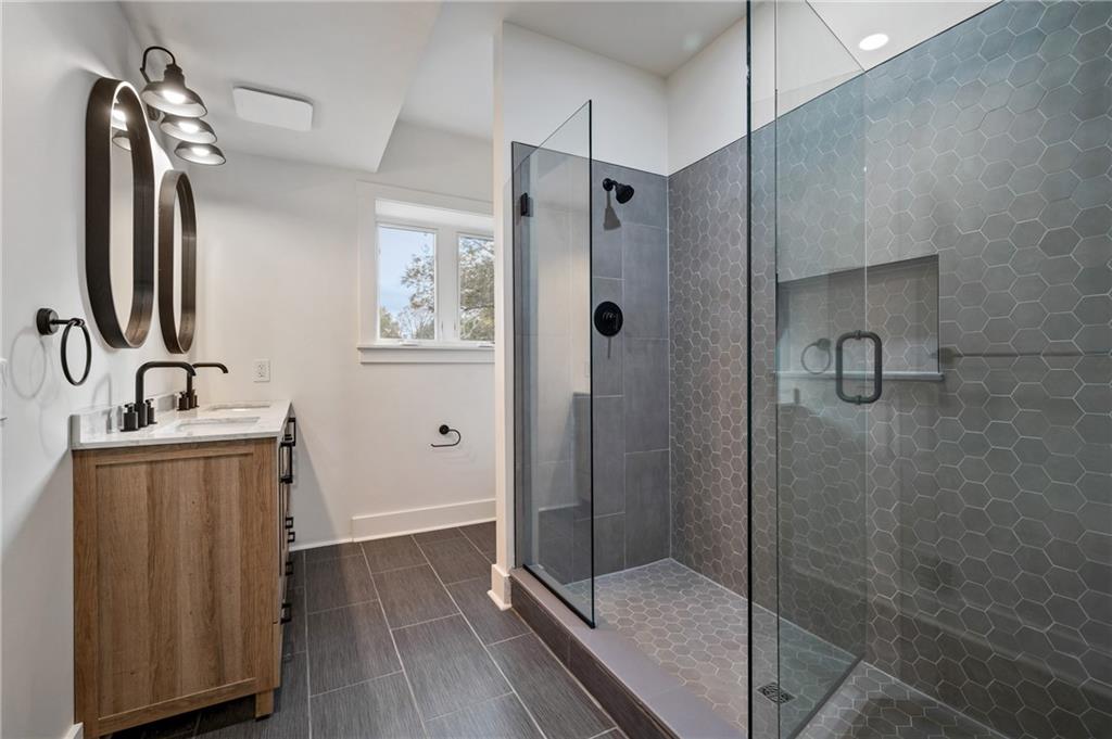 5563 Hampton Street Pittsburgh, PA 15206 - Photo 25 of 29 a bathroom with a shower sink and mirror
