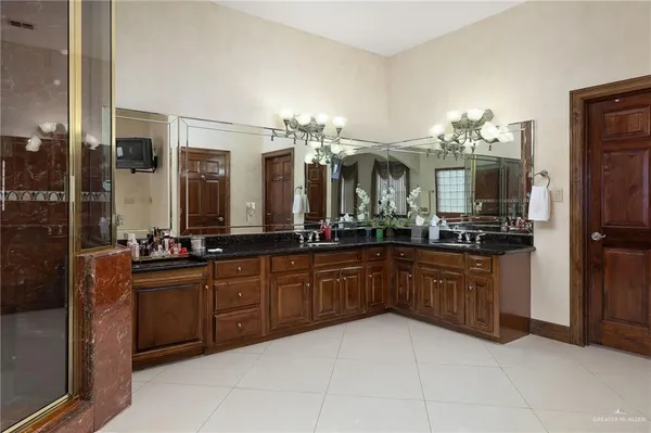 a spacious bedroom with a large bed and a chandelier