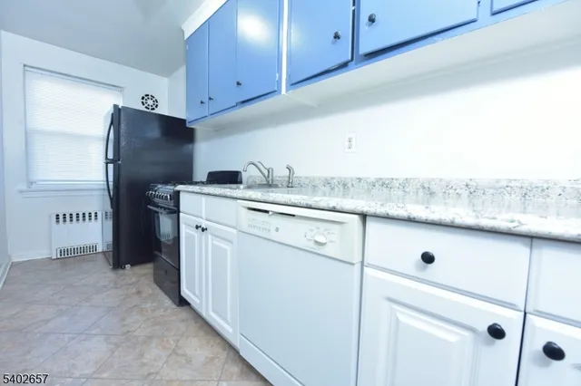 a kitchen with appliances a sink and cabinets
