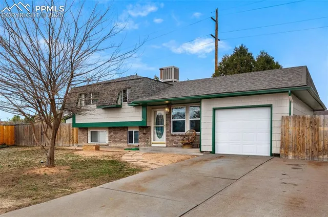 a front view of a house with a garden and trees