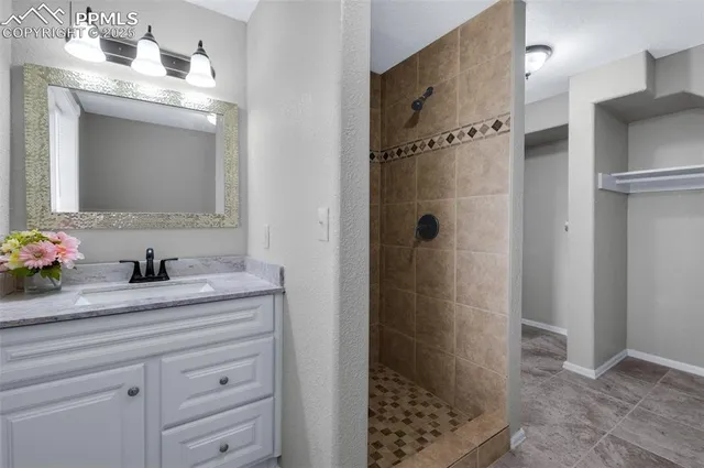 a bathroom with a granite countertop sink a mirror and shower