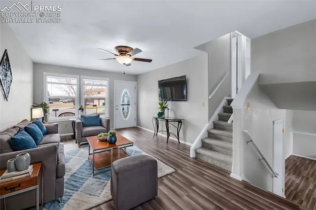 a living room with furniture a ceiling fan and a rug