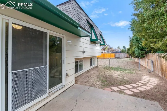 a white house that has tree in front of it