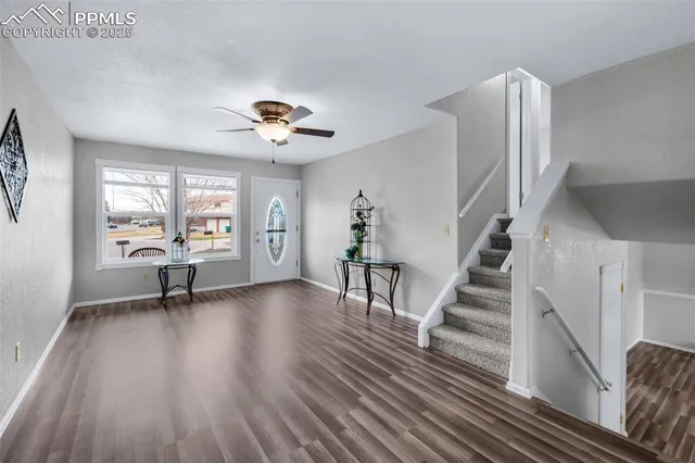 a view of a livingroom with wooden floor and a ceiling fan