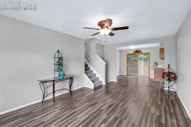 a view of a livingroom with wooden floor and a ceiling fan