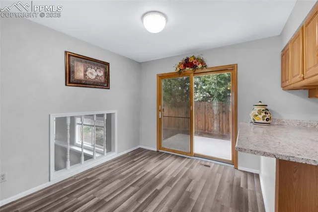 a view of a hallway with wooden floor and a living room
