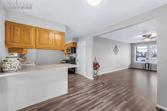 a kitchen with granite countertop a sink cabinets and wooden floor