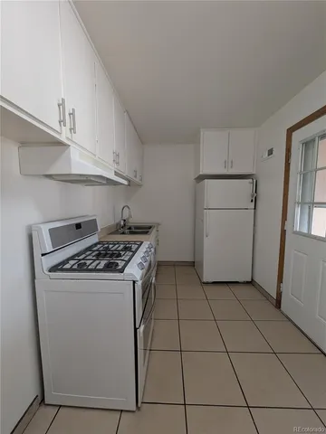 a kitchen with a stove top oven and cabinets
