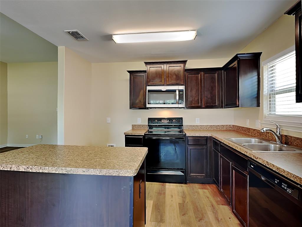 1334 Barrel Drive Dallas, TX 75253 - Photo 10 of 15 a kitchen with a sink a stove top oven a refrigerator and a sink
