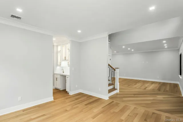 a large white kitchen with kitchen island a sink stainless steel appliances and cabinets