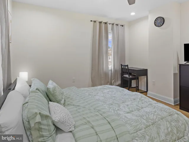 a bedroom with a bed and a lamp on dresser