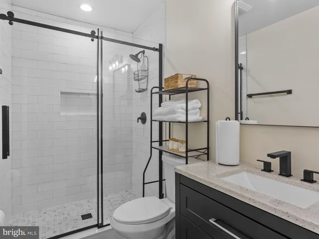 a bathroom with a granite countertop sink toilet and shower